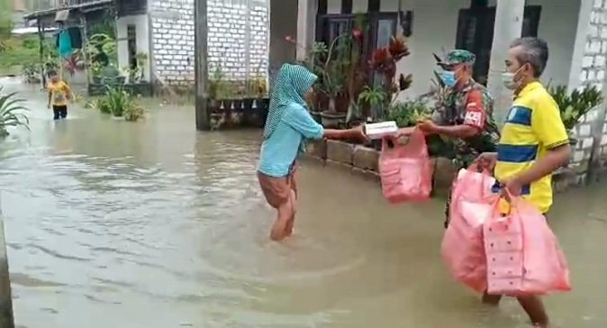 Susuri Banjir di Benjeng, Serda Untung Bagikan Nasi Kotak pada Warga Binaan